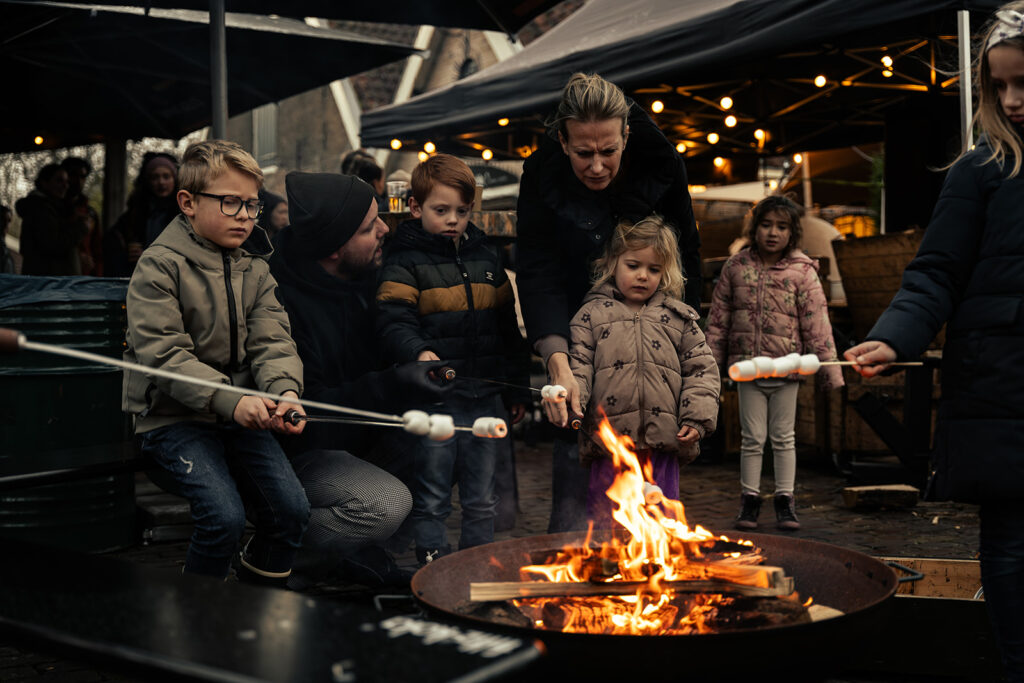 kinderen die een marshmellow boven het vuur houden